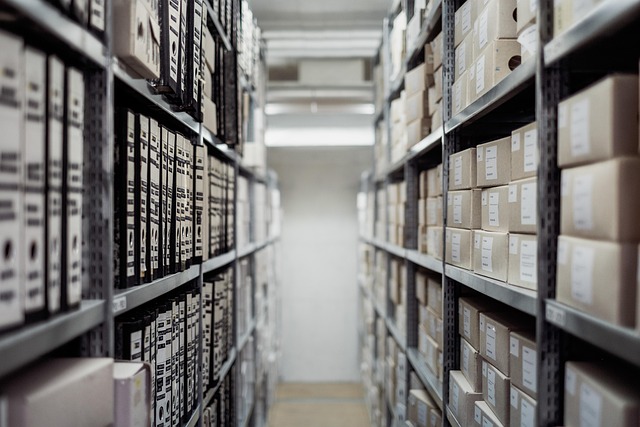 Picture of a hallway in an archive building, with books stacked on shelves.
