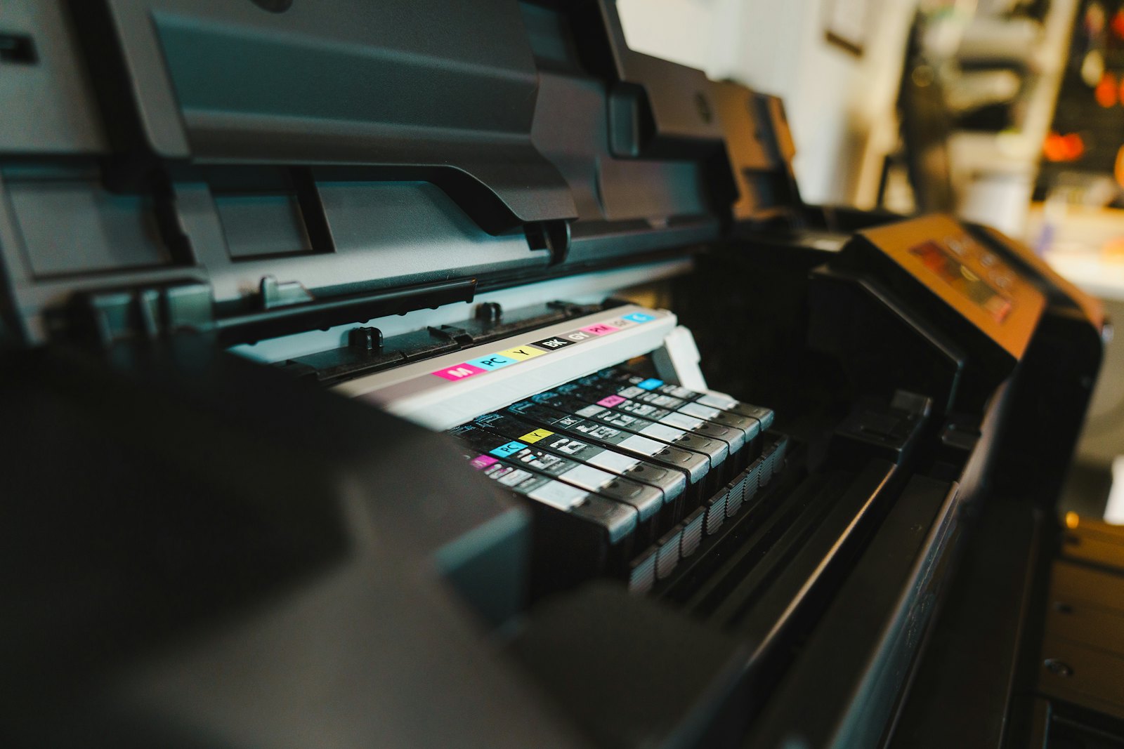 Close-up view of a color inkjet printer sitting on a desk, highlighting how color ink is consumed unnecessarily.