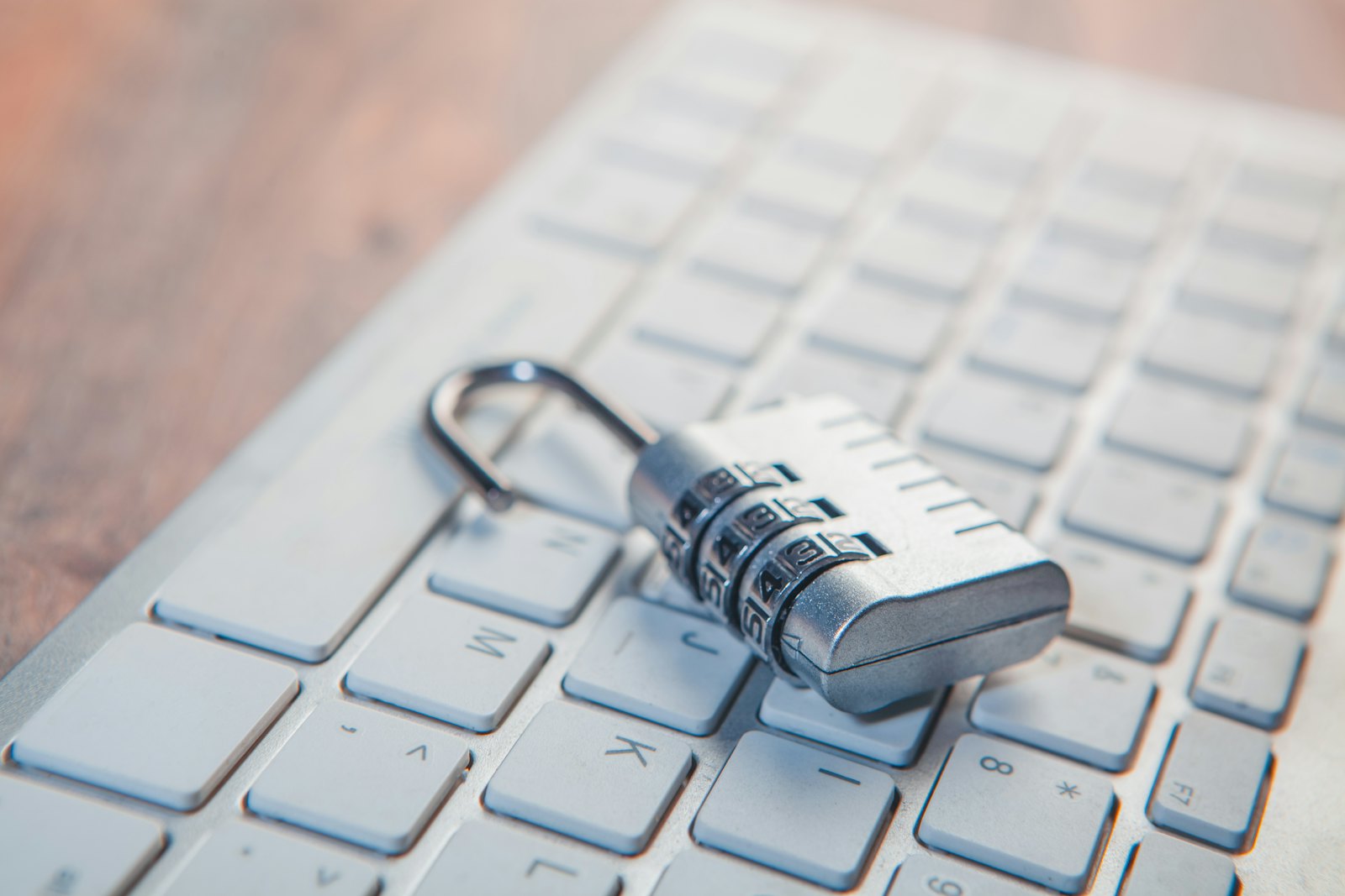 A combination padlock resting on a computer keyboard, symbolizing email security, authentication headers, and tamper-evident digital evidence.